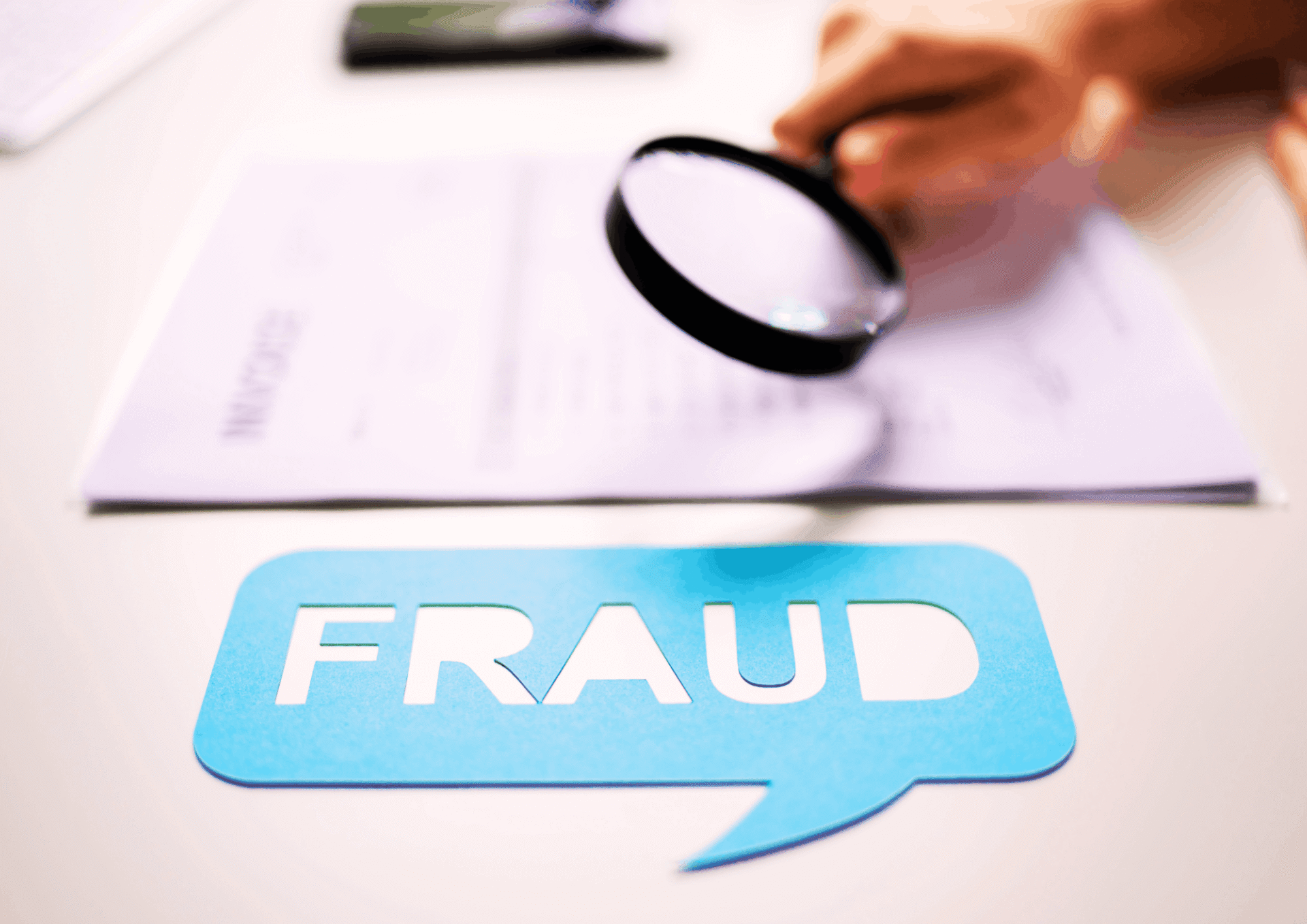 Magnifying glass examining documents with a fraud symbol during the tenant screening process